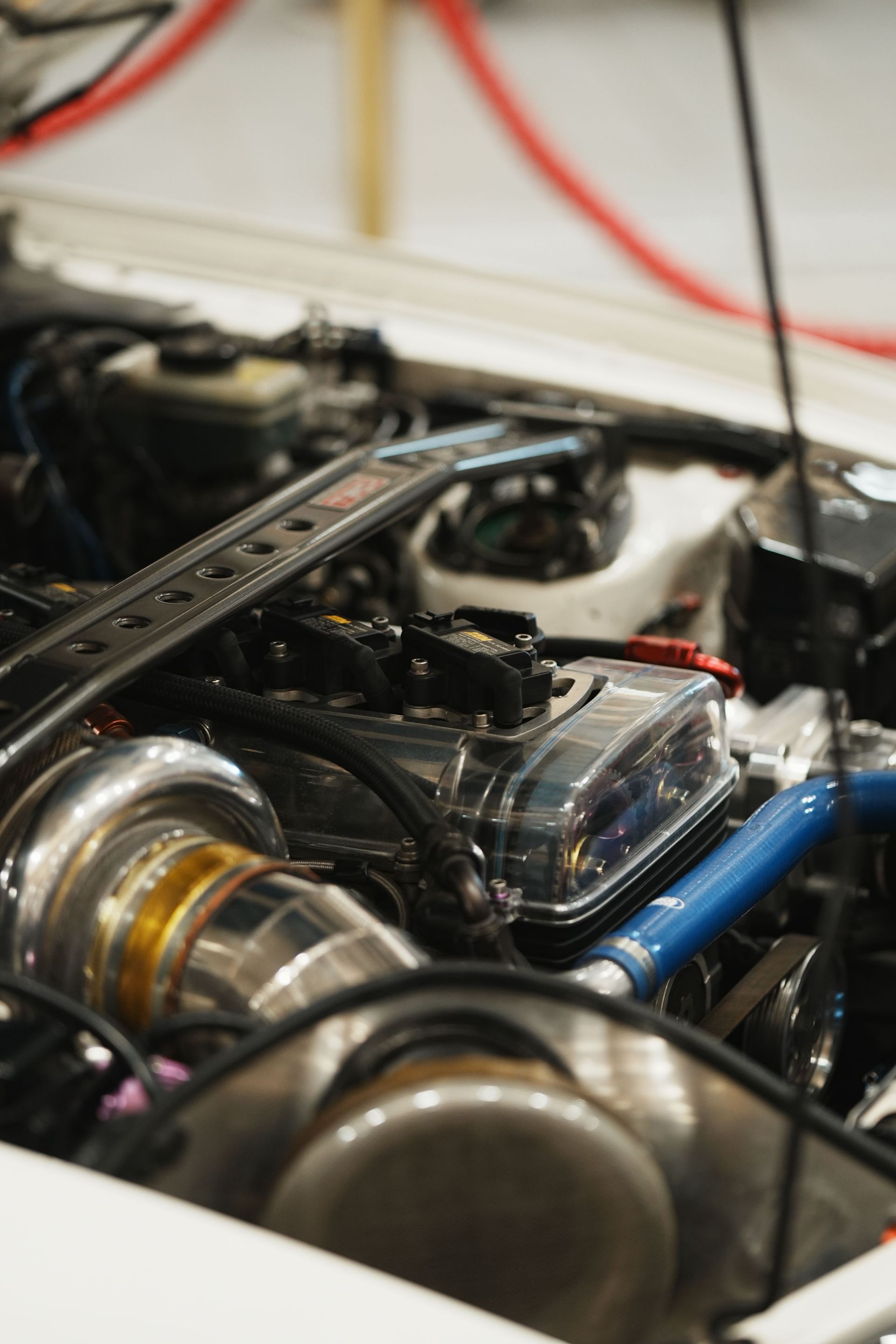 Detailed image of a high-performance car engine with visible turbocharger components in a workshop.